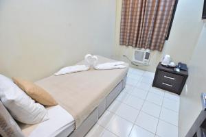 马尼拉马卡提阿麦克斯宾馆的一间设有床铺和毛巾的房间