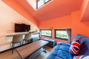 安平区群象商旅的橙色的客厅配有蓝色的沙发和桌子