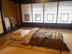Sakashitaゲストハウス　にじゅうよん的一张位于地板上的床,位于一个窗户的房间