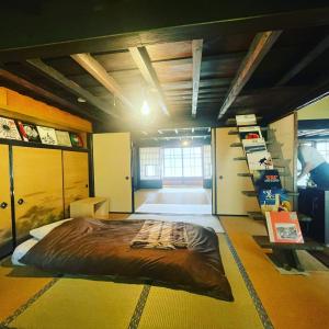 Sakashitaゲストハウス　にじゅうよん的卧室中间设有一张大床