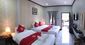 琅勃拉邦Le KhounSok Boutique Hotel的红色和白色的酒店客房内的两张床