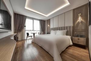 胡志明市La Siesta Premium Saigon的酒店客房设有一张大床和一张桌子。