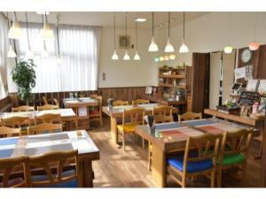 藤枝Fujieda Ogawa Hotel - Vacation STAY 20859v的餐厅设有木桌和椅子及灯