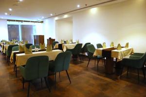 埃尔讷古勒姆Hotel Seven Lights的用餐室配有桌子和绿色椅子