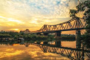 河内Marigold Hotel Hanoi的一条河上的火车桥,日落