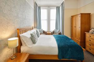 布里德灵顿坦尼森酒店的一间卧室配有一张床、一个梳妆台和一扇窗户。