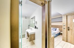 帕尔马诺瓦Leonardo Royal Hotel Mallorca Palmanova Bay的一间带水槽的浴室和一张位于客房内的床