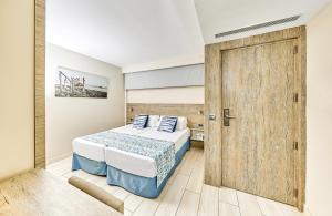 帕尔马诺瓦Leonardo Royal Hotel Mallorca Palmanova Bay的一间卧室配有一张床和一扇木门