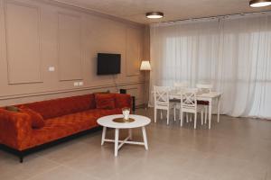 内坦亚Стильные апартаменты Dotan的客厅配有沙发和桌椅