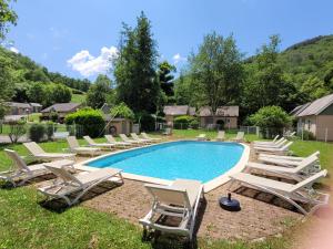 孔克Village de 19 gites avec Piscine et restaurant, Grand Vabre Nature的一个带躺椅的游泳池