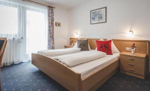 卡迪皮特拉Garni Appartement Alpenresidence的一间卧室配有一张带红色枕头的大床