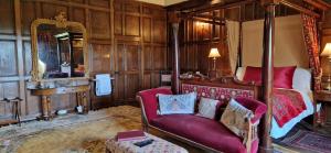 米德尔赫姆Braithwaite Hall Bed & Breakfast的一间卧室配有一张床、一张沙发和一面镜子