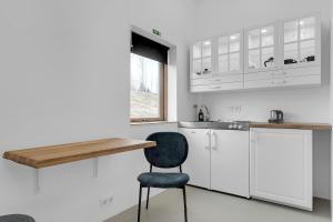 弗吕济Klettar - The Old Hatchery Iceland的厨房配有白色橱柜和蓝色椅子