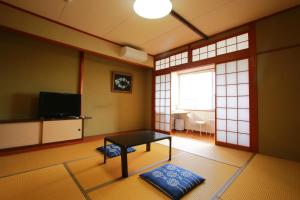 指宿市Family Ryokan Kawakyu with Showa Retro, private hot spring的客厅配有桌子和电视