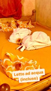 亚历山德里亚Dormi nella SPA privata con letto ad acqua, sauna, doccia emozionale e kneipp的一张带两条白色毛巾的床和上面的标志