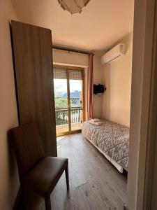 卡拉拉hotel La pineta的卧室配有床、椅子和窗户。