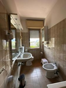 卡拉拉hotel La pineta的浴室设有2个水槽、卫生间和镜子。