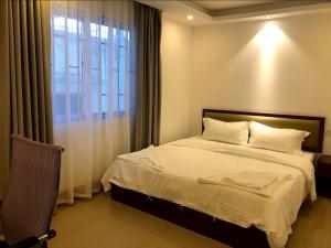 金边Yaou Hotel的一间卧室设有一张大床和一个窗户。