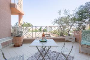 利勒鲁斯U Momentu - appt climatisé avec terrasse的阳台的天井配有桌椅