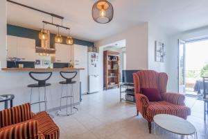 利勒鲁斯U Momentu - appt climatisé avec terrasse的厨房以及带椅子和柜台的起居室。