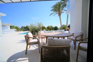 佩亚Luxury 4 Bedroom Oasis Villa的一个带桌椅的庭院和一个游泳池