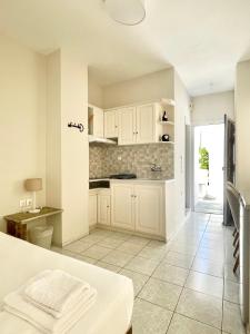 提诺斯曼托公寓式酒店的厨房配有白色橱柜和瓷砖地板。