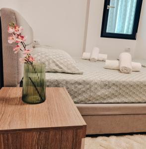 加拉茨Bijou Aparthotel的花瓶坐在床边的桌子上