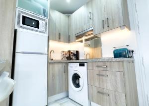 马贝拉Skol 438 Super One-bedroom Apartment with Sea Views的厨房配有白色冰箱、洗衣机和烘干机