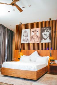 布琼布拉Burundi Palace Boutique Hotel的卧室配有一张墙上挂有照片的床