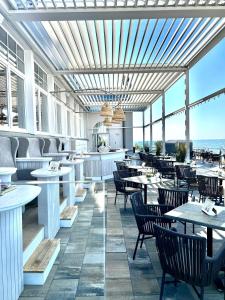 奥斯赛拜-屈隆斯博恩meergut HOTELS的一间带桌椅的海景餐厅