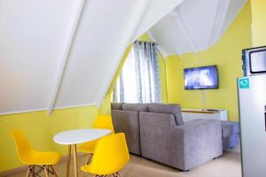 内罗毕Charming 1-Bed Penthouse in Karen Nairobi的客厅配有沙发和桌椅