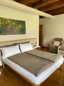 阿科Casa Andela的一间卧室配有一张大床和一把椅子