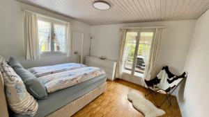 WirzweliThe Swiss Paradise 2 Apartment with Garden, Whirlpool, and Mountain Panorama的一间卧室设有一张床和两个窗户。
