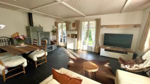 WirzweliThe Swiss Paradise 2 Apartment with Garden, Whirlpool, and Mountain Panorama的客厅配有电视和桌椅