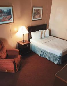 威利斯顿FairBridge Inn & Suites Williston的酒店客房,配有两张床和椅子