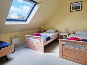 洛克马里亚Les Maisons de Kerdavid'île的阁楼卧室设有两张床和窗户。