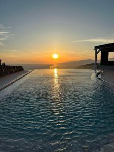 胡拉吉亚White Rock Suites & Villas的一座享有日落美景的无边游泳池