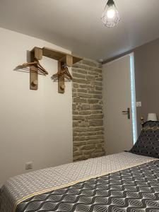 FusseyLe Cocon des Hautes-Côtes的一间卧室设有一张床和石墙