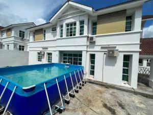 浮罗山背Penang Balik Pulau Swimming Pool BBQ Homestay的一座房子前面设有游泳池