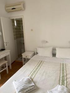 安迪帕罗斯岛Korali Hotel的白色卧室配有带2条毛巾的床