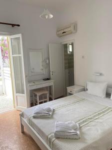 安迪帕罗斯岛Korali Hotel的白色卧室配有床和镜子
