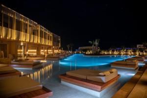 赫索尼索斯SENSEANA Sea Side Resort & Aquadventure的游泳池(带躺椅)