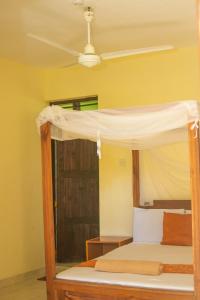 KikambalaMsafiri Bed & Breakfast的天花板房间的一张带天蓬的床