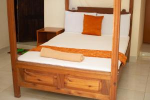 KikambalaMsafiri Bed & Breakfast的一张带白色床单和橙色枕头的木制双层床