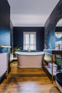 温莎Beautiful 4-bed Luxury Windsor Home by Casa by Grace, Amazing location, Perfect for large groups, Pet Friendly, sleeps 7-9!的带浴缸的浴室和蓝色的墙壁