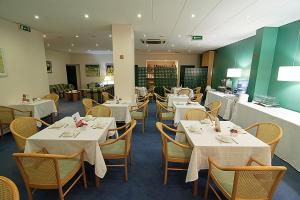 波尔图杜罗酒店的一间设有白色桌椅的用餐室