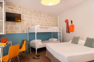 巴黎蒙马特丽晶嘻哈旅舍的客房设有两张床和一张双层床。