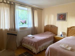 塔林特努玛公寓酒店的一间卧室设有两张床和鲜花窗户。