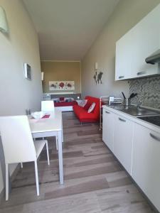 莱韦拉诺Martylè Rooms的厨房配有白色桌子和红色沙发