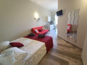 莱韦拉诺Martylè Rooms的一间卧室配有两张床和一张红色沙发